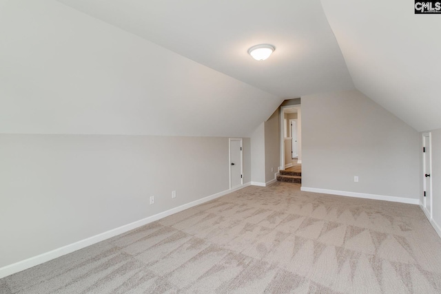 bonus room featuring lofted ceiling, carpet floors, and baseboards