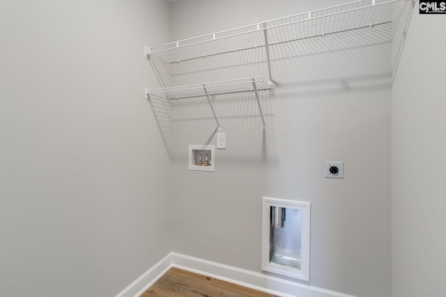 clothes washing area featuring hookup for a washing machine, hookup for an electric dryer, wood finished floors, laundry area, and baseboards