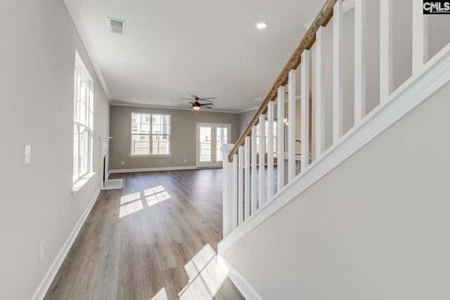 foyer with stairs, visible vents, crown molding, and wood finished floors