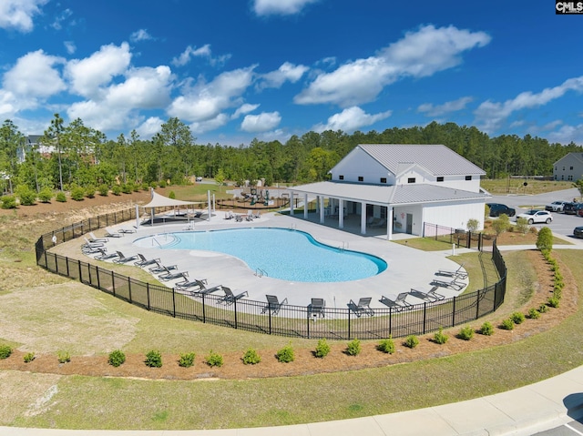 pool with a patio area and fence