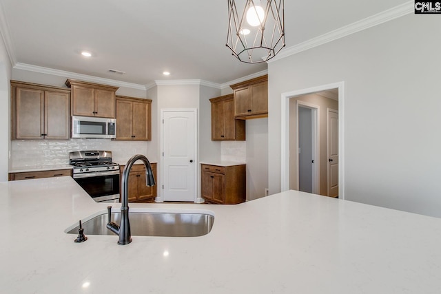 kitchen with stainless steel appliances, light countertops, brown cabinetry, and a sink