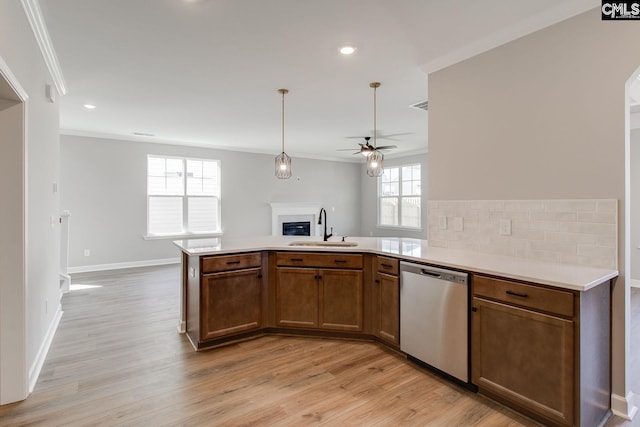 kitchen with crown molding, open floor plan, a sink, and stainless steel dishwasher