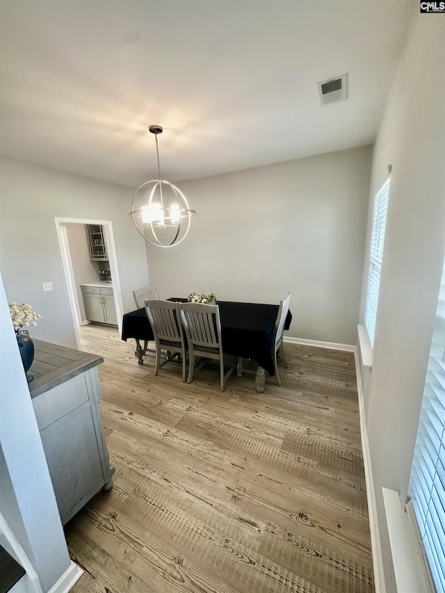 dining room with a notable chandelier and light hardwood / wood-style floors