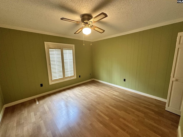 spare room with ceiling fan, ornamental molding, hardwood / wood-style floors, and a textured ceiling