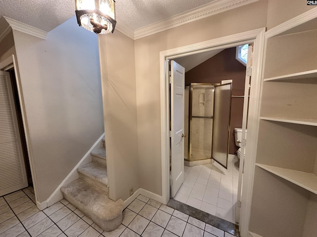 bathroom with tile patterned flooring, an inviting chandelier, a textured ceiling, and ornamental molding