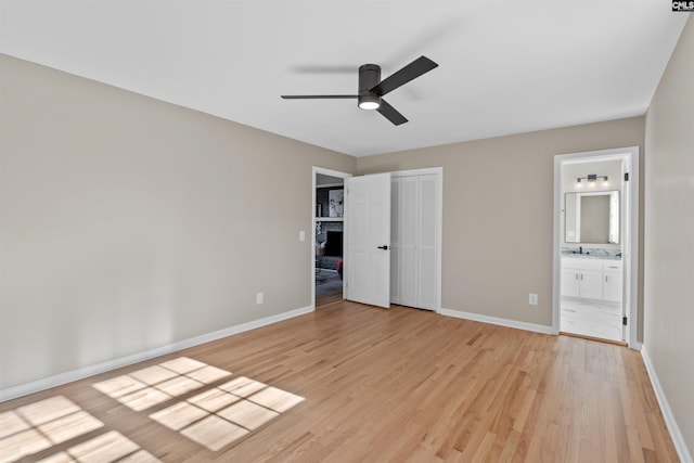 unfurnished bedroom with ensuite bathroom, ceiling fan, a closet, and light hardwood / wood-style flooring