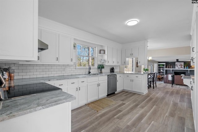 kitchen featuring white cabinets, sink, kitchen peninsula, light stone counters, and stainless steel dishwasher