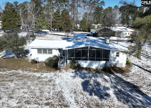 snow covered house with a sunroom