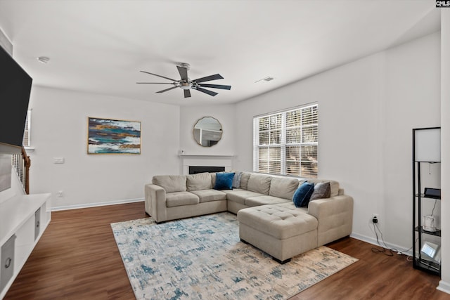 living room featuring ceiling fan and dark hardwood / wood-style flooring