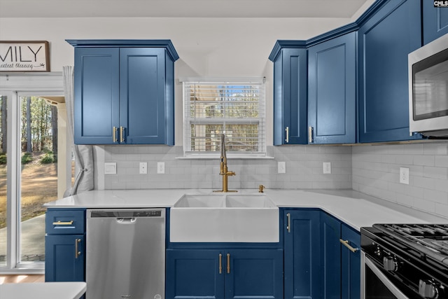 kitchen with appliances with stainless steel finishes, blue cabinets, and sink