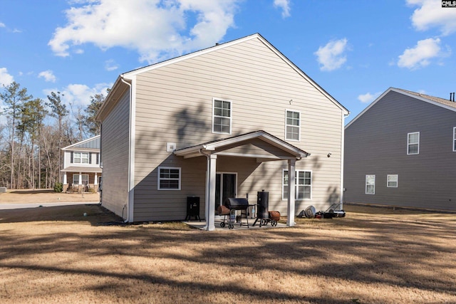 rear view of property with a lawn and a patio area