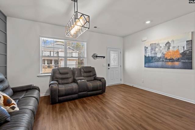 living room with dark hardwood / wood-style floors and a notable chandelier