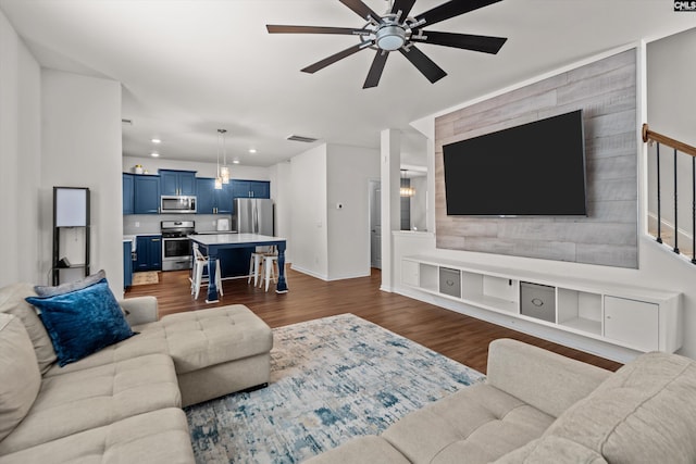 living room with ceiling fan and dark hardwood / wood-style flooring