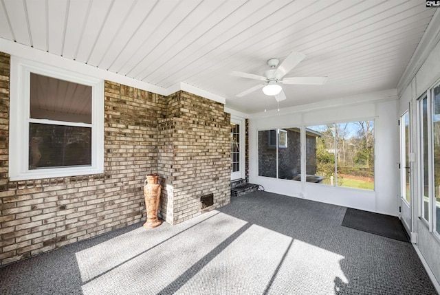 unfurnished sunroom with ceiling fan