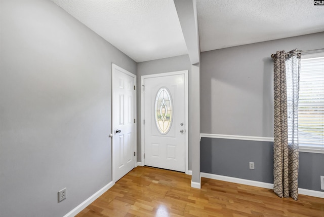 entrance foyer featuring plenty of natural light, wood-type flooring, and a textured ceiling