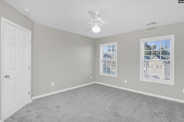 empty room with ceiling fan and light carpet