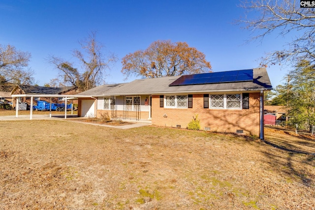 back of house with a lawn, solar panels, a carport, and covered porch