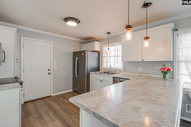 kitchen with appliances with stainless steel finishes, white cabinetry, sink, hanging light fixtures, and kitchen peninsula