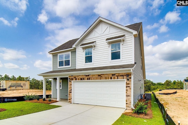 view of front of home with a front yard, central AC, and a garage