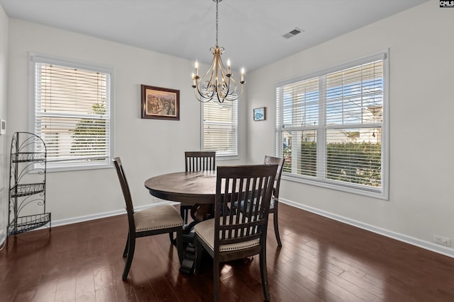 dining area with an inviting chandelier and dark hardwood / wood-style floors