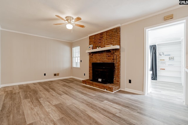 unfurnished living room featuring ceiling fan, light hardwood / wood-style flooring, a brick fireplace, and crown molding