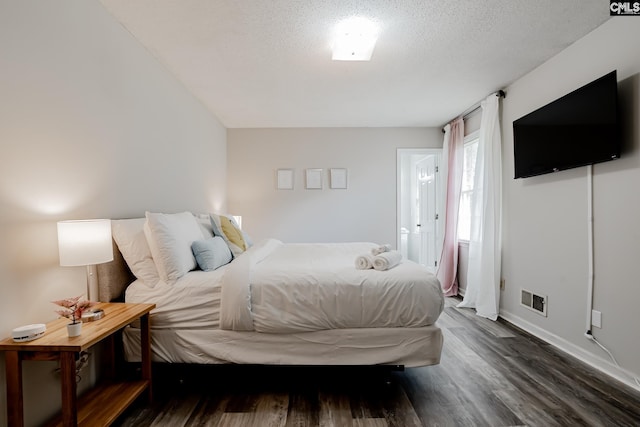 bedroom with dark wood-type flooring and a textured ceiling