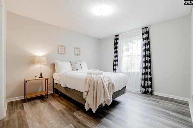 bedroom with hardwood / wood-style flooring and a textured ceiling