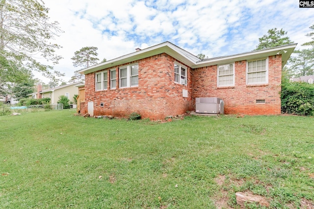 exterior space with a lawn and central AC