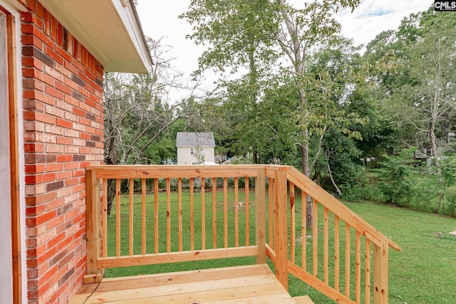 wooden terrace featuring a yard