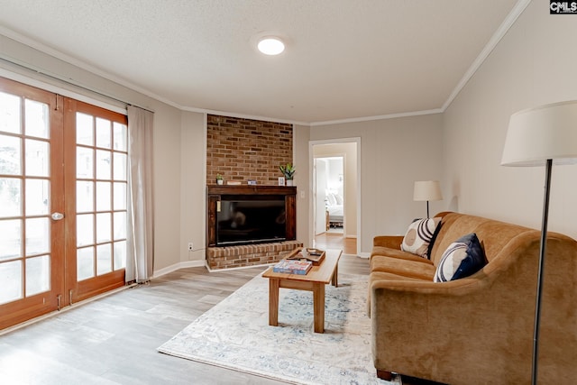 living room featuring a brick fireplace, light hardwood / wood-style flooring, ornamental molding, and french doors