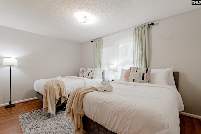 bedroom with hardwood / wood-style floors and a textured ceiling