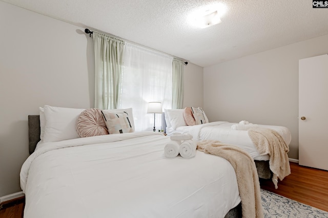 bedroom featuring a textured ceiling and hardwood / wood-style floors