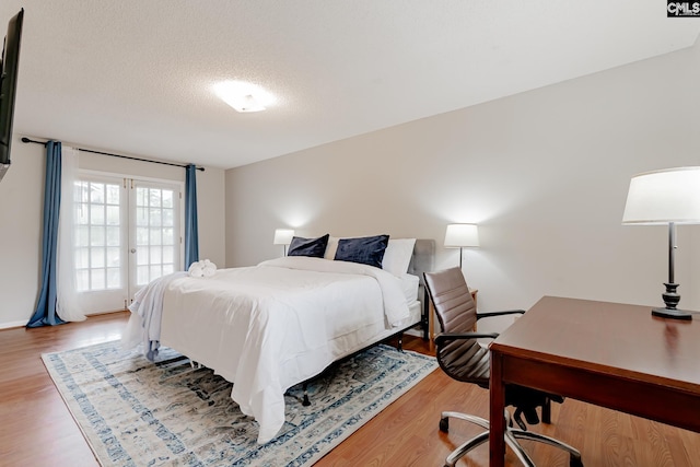 bedroom featuring light hardwood / wood-style floors and a textured ceiling