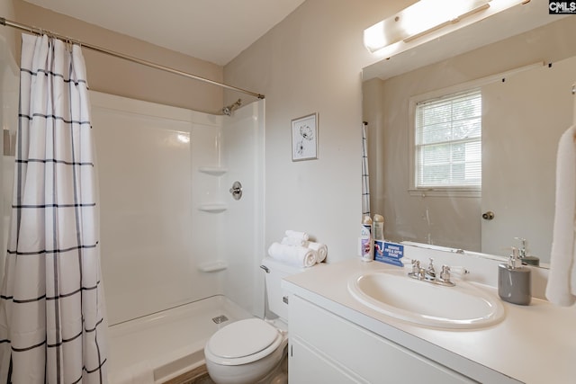 bathroom featuring vanity, toilet, and a shower with shower curtain