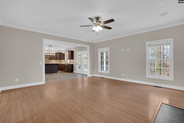 unfurnished living room featuring light hardwood / wood-style floors, ornamental molding, and ceiling fan