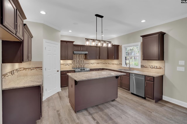 kitchen featuring appliances with stainless steel finishes, a center island, sink, hanging light fixtures, and ornamental molding