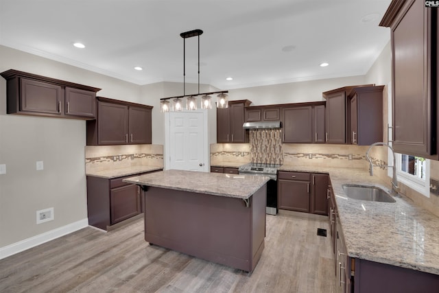 kitchen featuring light hardwood / wood-style flooring, sink, decorative light fixtures, electric range, and a center island