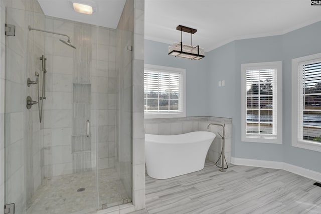 bathroom featuring a wealth of natural light, ornamental molding, and shower with separate bathtub