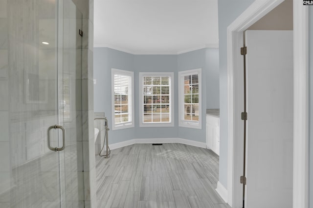 bathroom featuring a shower with shower door and crown molding