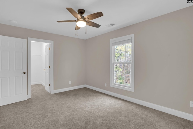 spare room with ceiling fan and light colored carpet