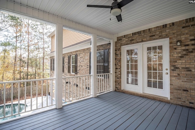 unfurnished sunroom featuring ceiling fan