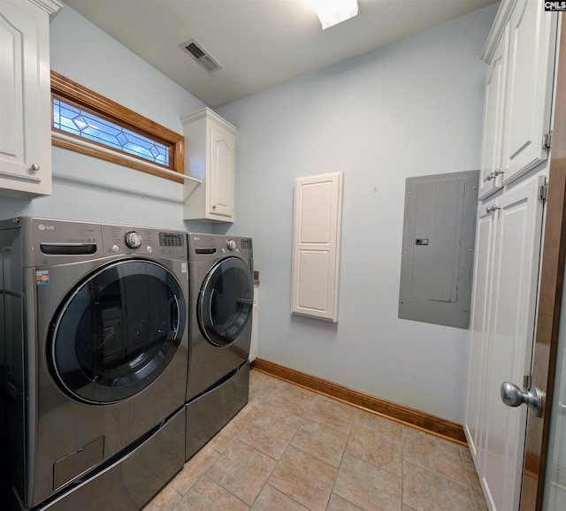 clothes washing area featuring washer and clothes dryer, cabinets, and electric panel