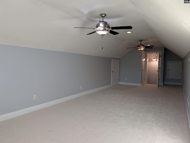 bonus room with light colored carpet, a textured ceiling, and lofted ceiling