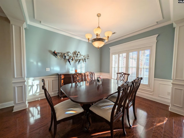 dining space with decorative columns, ornamental molding, a notable chandelier, and dark wood-type flooring