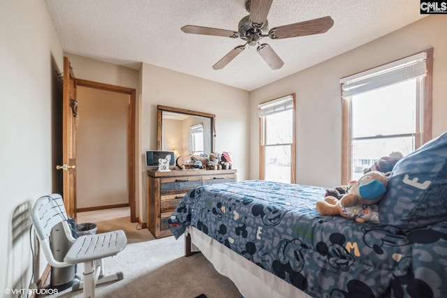 carpeted bedroom with ceiling fan and a textured ceiling