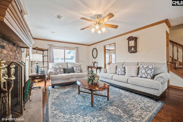 living room with ornamental molding, dark hardwood / wood-style floors, ceiling fan, and a fireplace