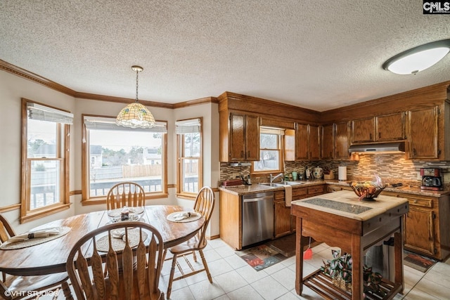 kitchen featuring sink, tasteful backsplash, light tile patterned flooring, decorative light fixtures, and stainless steel dishwasher