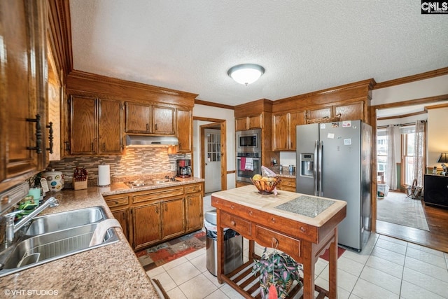 kitchen featuring tasteful backsplash, sink, crown molding, and stainless steel appliances