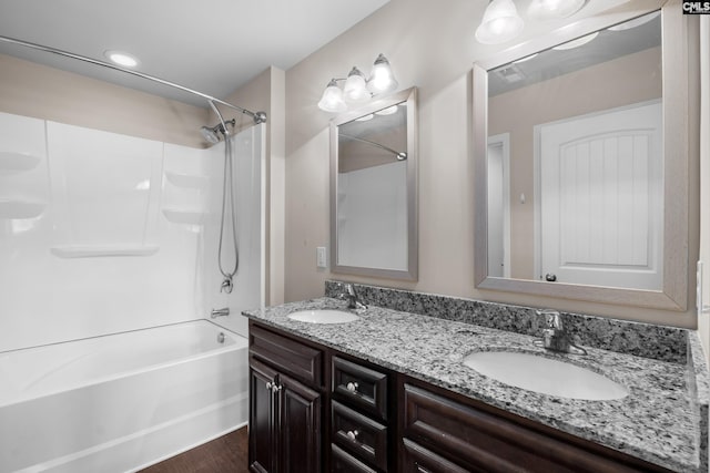 bathroom with hardwood / wood-style flooring, vanity, and shower / washtub combination