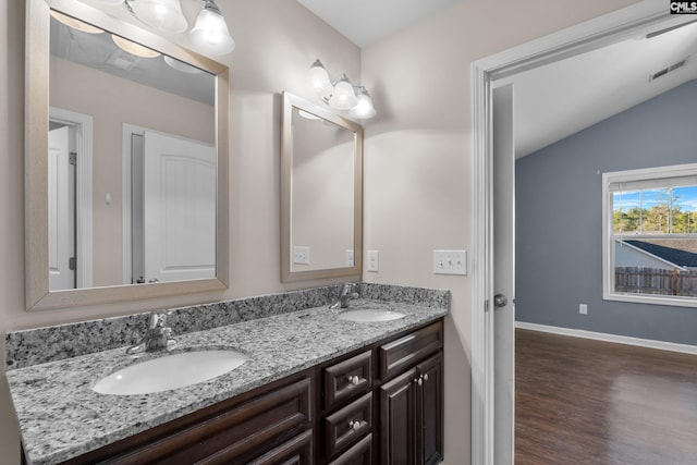 bathroom featuring vanity, wood-type flooring, and lofted ceiling